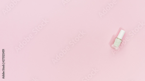 White bottle of nail polish on pink background with copy space for writing the text