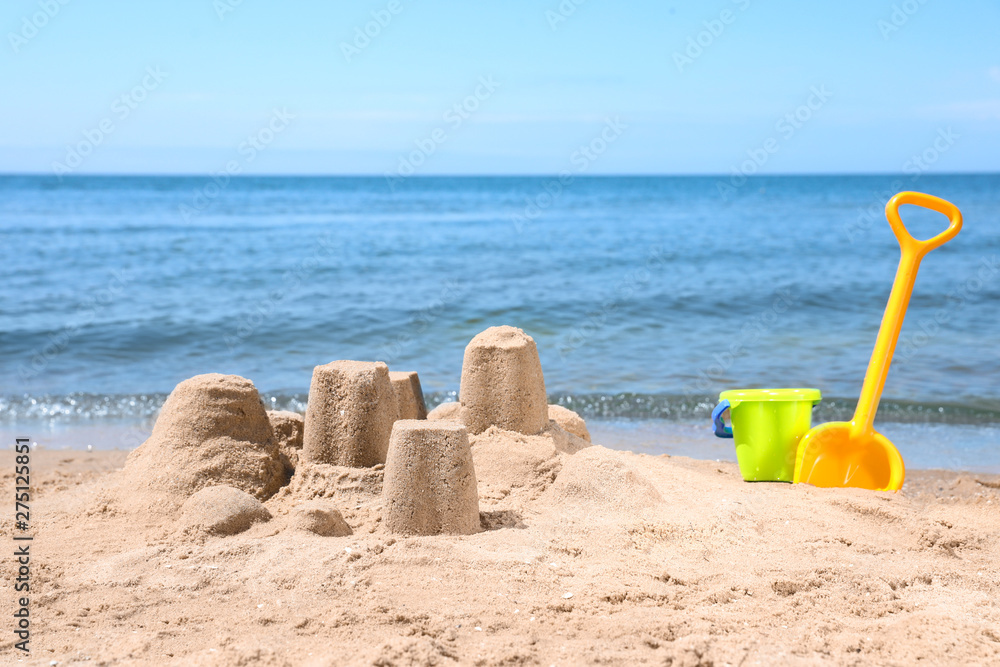 Little sand figures and plastic toys on beach near sea Little sand figures and plastic toys on beach near sea