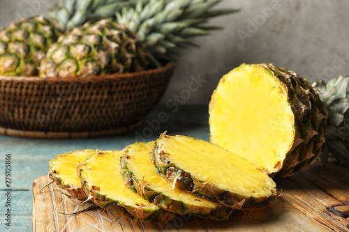 Board with cut fresh juicy pineapple on wooden table, closeup