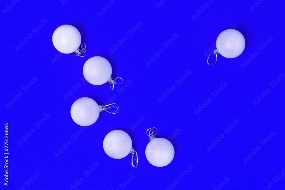 New Year glass balls on blue paper background. Happy holiday christmas concept. Bright xmas greeting card. Top view. Flat lay.