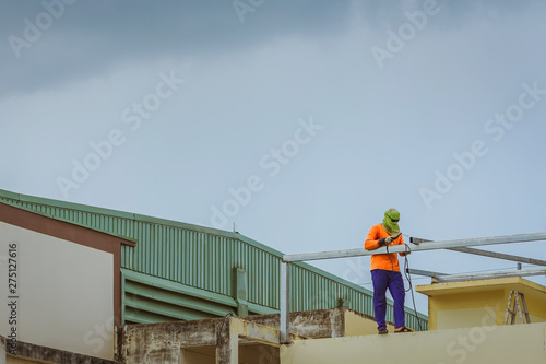Wallpaper Mural Worker welding the steel part for roof  before it is going to rain. Torontodigital.ca