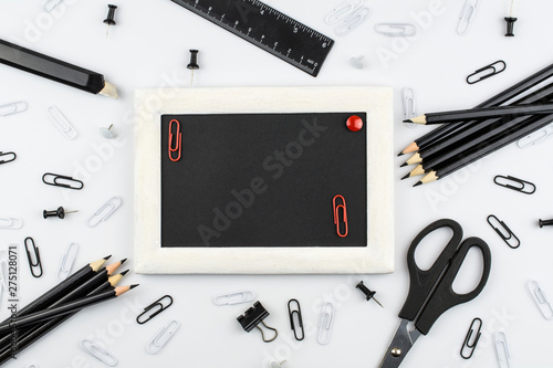  Frame for text, black school and office stationery lie on a white background.