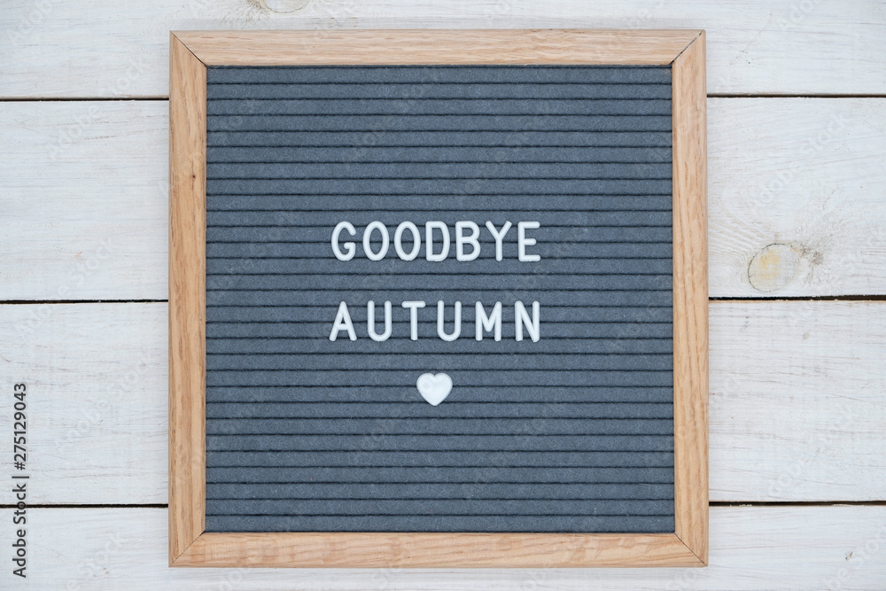 English text goodbye autumn on a letter Board in white letters on a gray background and a symbol of heart
