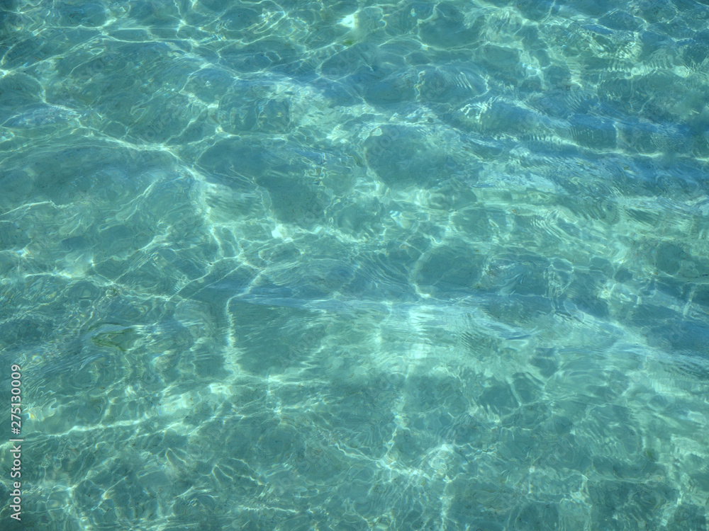 clear water with shadows from the waves in the sand