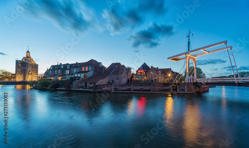 The center of Enkhuizen in the Netherlands with the old city gate - Drommedaris in the background, during the blue hour - dusk.. photo