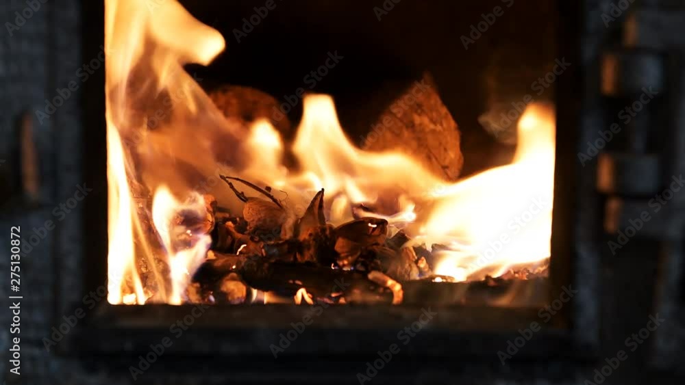 Macro closeup of fire flame in traditional Russian oven furnace with wood burning, opened cast iron doors Macro closeup of fire flame in traditional Russian oven furnace with wood burning, opened cast iron doors