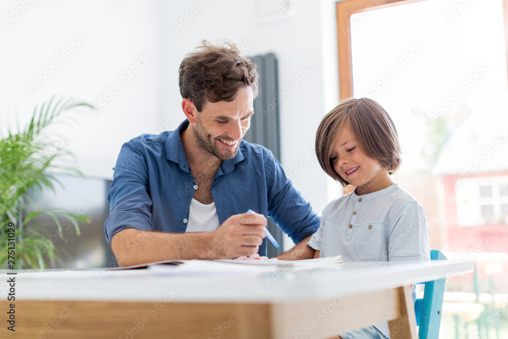 Father and son doing homework together at home