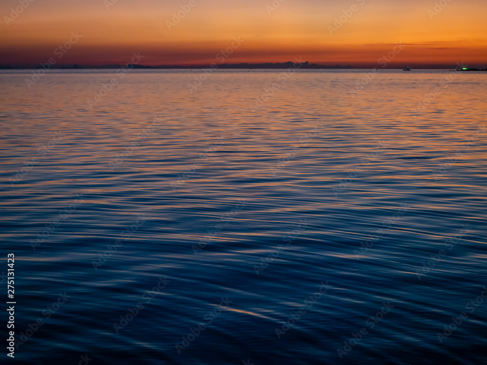 The texture of the water at sunset with sun reflections