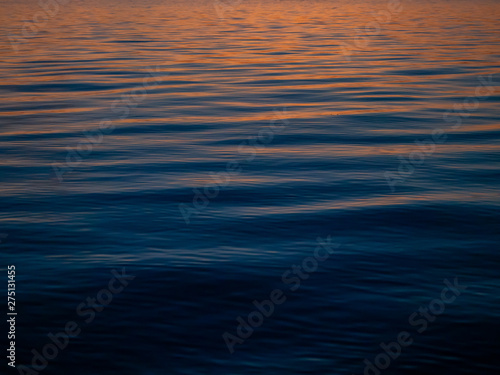 The texture of the water at sunset with sun reflections