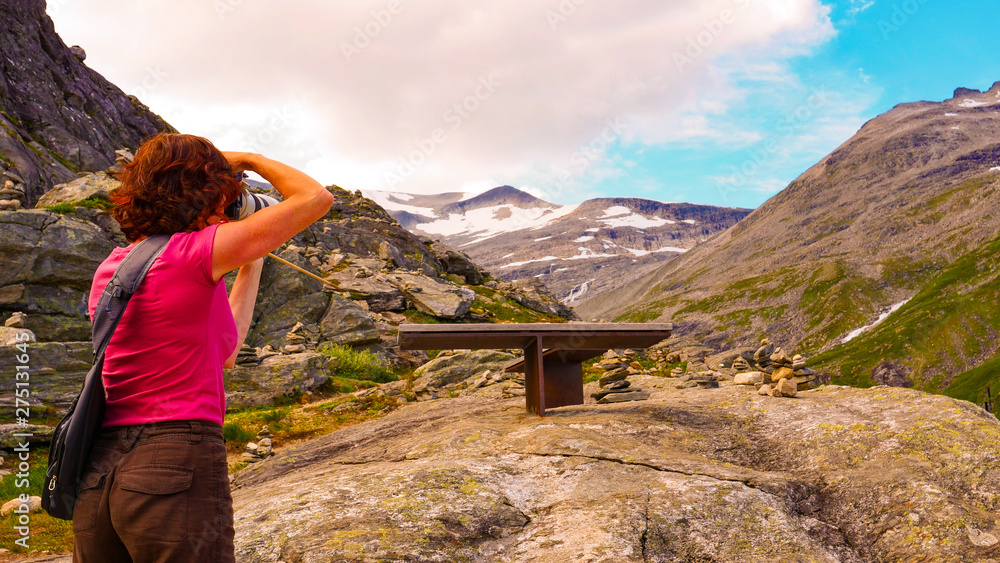 Naklejka premium Tourist with camera on Trollstigen viewpoint
