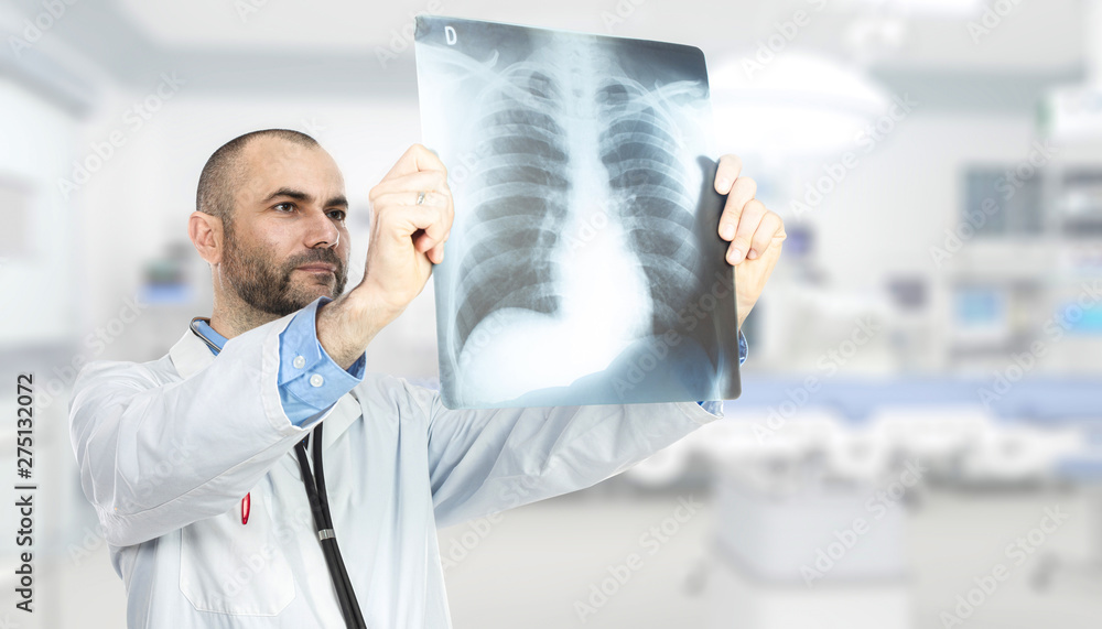 portrait of a caucasian doctor checking an x-ray inside the hospital. portrait of a caucasian doctor checking an x-ray inside the hospital.