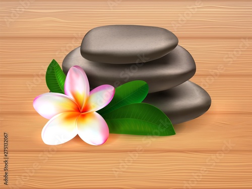 spa stones with plumeria flower on wooden background