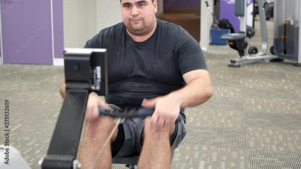 Young male using a rowing machine. Young male using a rowing machine.