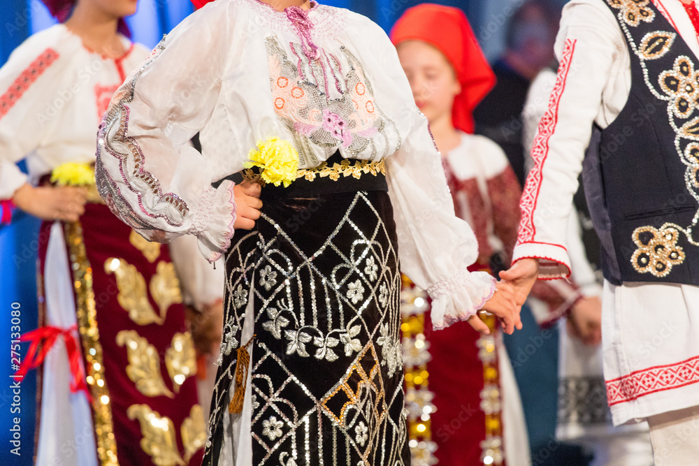 Close up of hands of young Romanian dancers perform a folk dance in traditional folkloric costume. Folklore of Romania