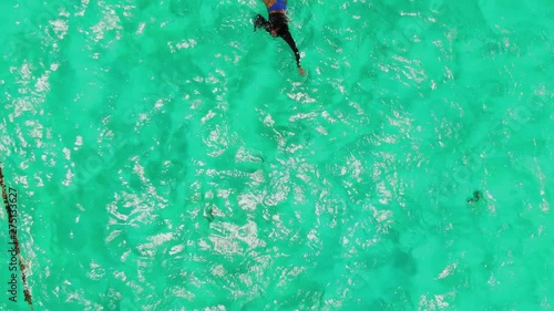 Bikini swimsuit model swimming in the crystal clear waters of Tobago Cays photo