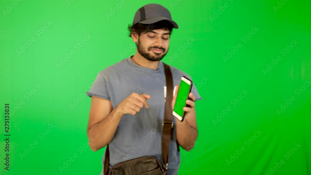 guy using mobile / tablet with green screen and green background indian guy with green screen guy using mobile / tablet with green screen and green background indian guy with green screen