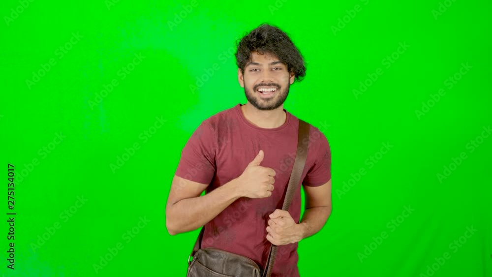 indian tourist standing and looking on camera with green background / green screen indian tourist standing and looking on camera with green background / green screen