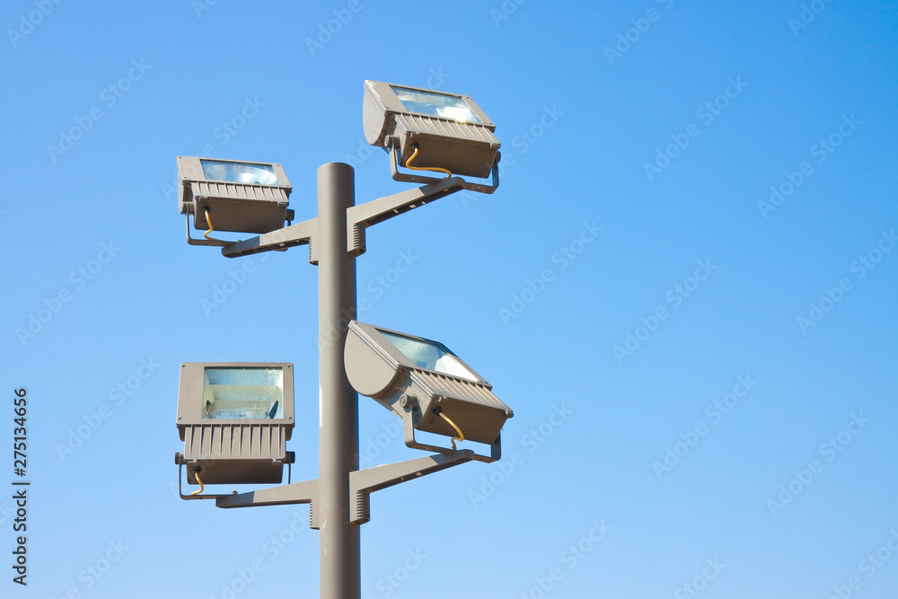 Four lamps projecting light toward an architecture Four lamps projecting light toward an architecture