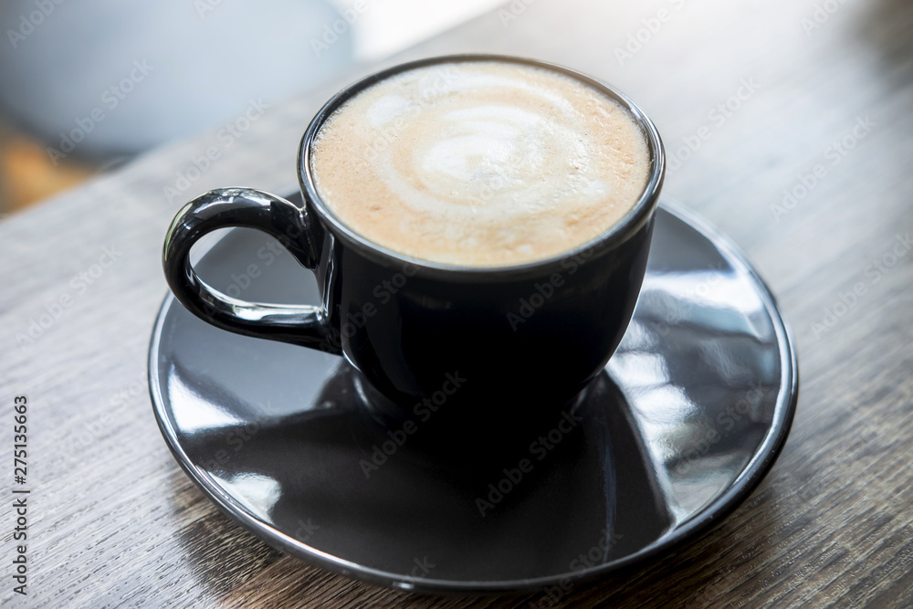 Obraz premium Black Cup of coffee with milk foam so delicious on old wooden table