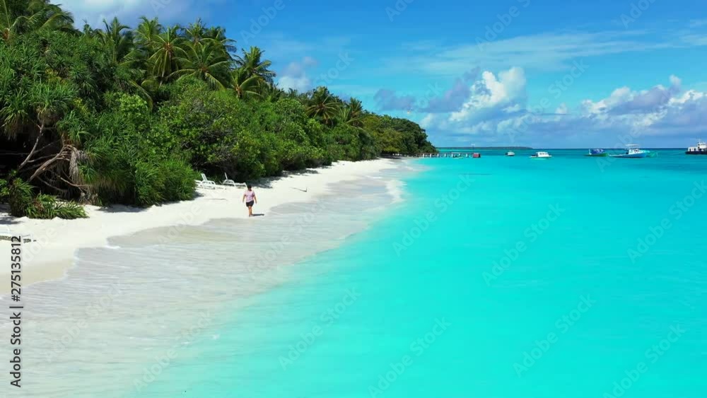 woman walking barefoot on Perfect Wild Sandy Maldives Beach With Turquoise crystal clear sea water, aerial drone dolly out shot woman walking barefoot on Perfect Wild Sandy Maldives Beach With Turquoise crystal clear sea water, aerial drone dolly out shot