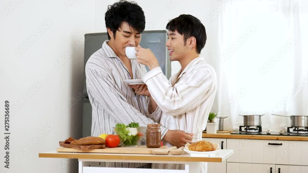 Gay couple homosexual cookking together in the kitchen make a breakfast relation fall in love. LGBTQ relation lifestyle concept. Gay couple homosexual cookking together in the kitchen make a breakfast relation fall in love. LGBTQ relation lifestyle concept.