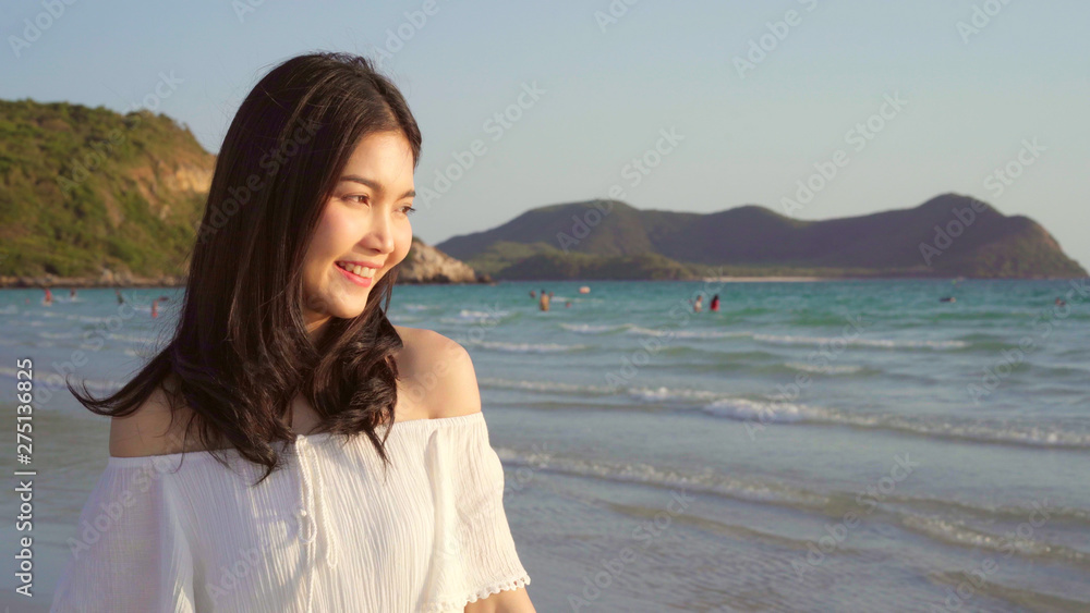Young Asian woman walking on beach. Beautiful female happy relax walking on beach near sea when sunset in evening. Lifestyle women travel on beach concept. Young Asian woman walking on beach. Beautiful female happy relax walking on beach near sea when sunset in evening. Lifestyle women travel on beach concept.