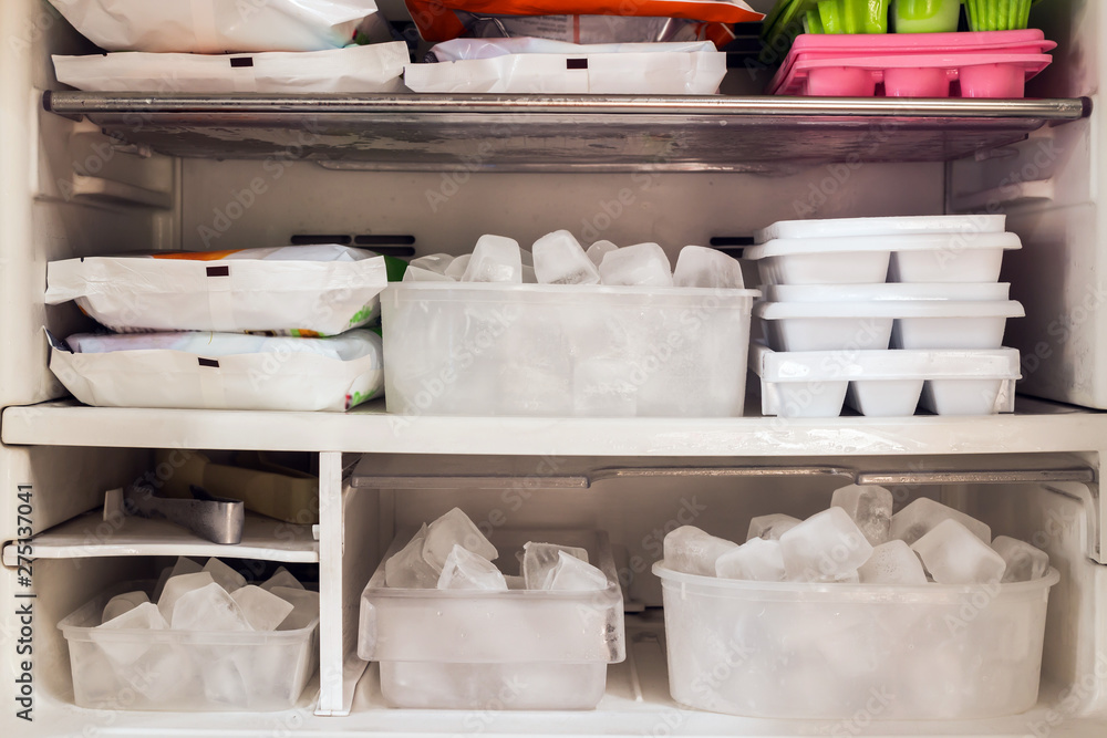 Freezer full of ice cubes and frozen food Freezer full of ice cubes and frozen food