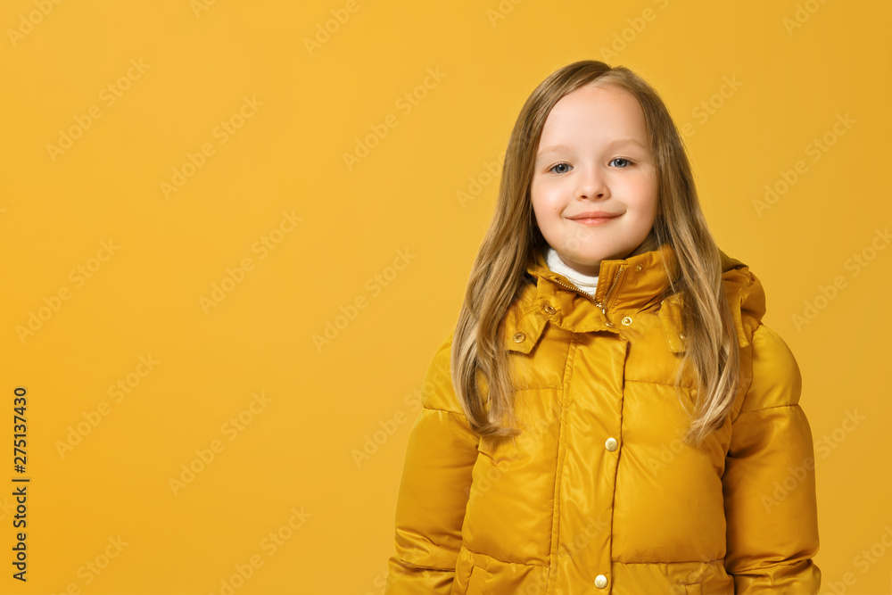 Portrait of a cheerful little girl in jacket over yellow background. Autumn concept. Copy space Portrait of a cheerful little girl in jacket over yellow background. Autumn concept. Copy space