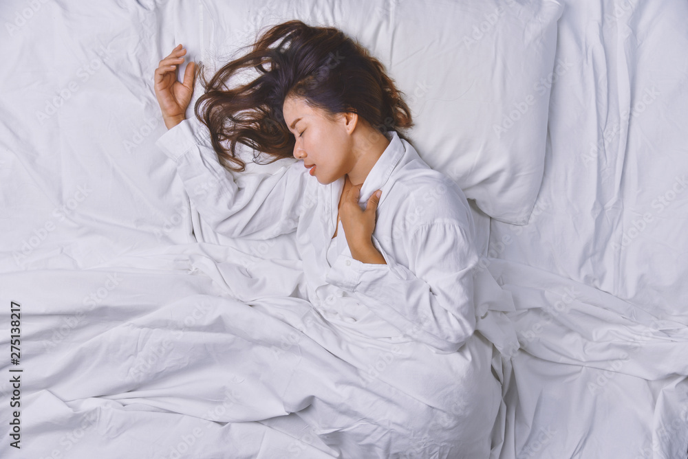 Young Woman Sleeping In Bed. Top view of young woman lying down sleeping well in bed. sleeping