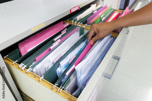 Hand of Man Search files document in a file cabinet in work office photo