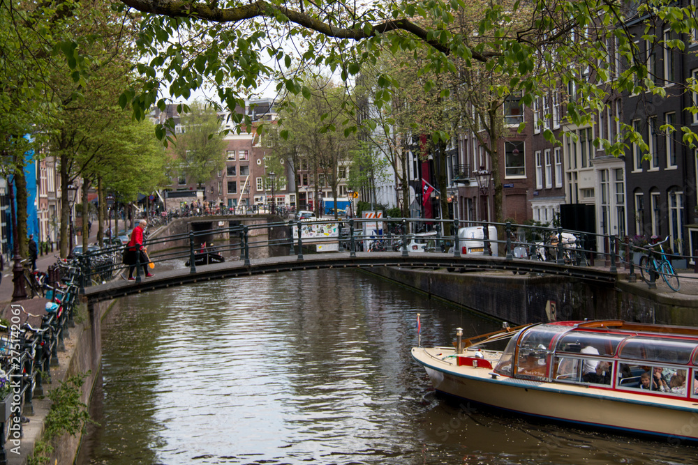 Tourist Canal Boats in the Herengracht (Gentlemen's Canal) with its large historic houses in the city center of Amsterdam