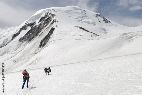 Western Mongolia mountainous landscape. Group of climbers climb down Khuiten Peak (4374 m, the highest summit in Mongolia). Altai Tavan Bogd National Park, Bayan-Ulgii Province, Mongolia.