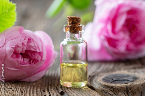 A bottle of rose essential oil with cabbage roses