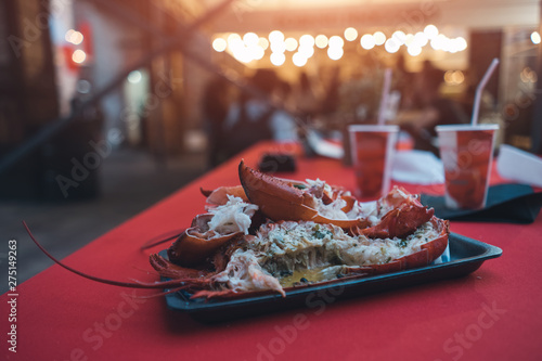 fresh red boiled lobster in paper plate on food festival photo