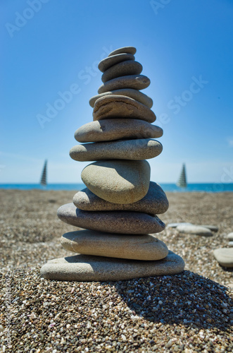 Stones pyramid on pebble beach symbolizing stability  zen  harmony  balance. Shallow depth of field.