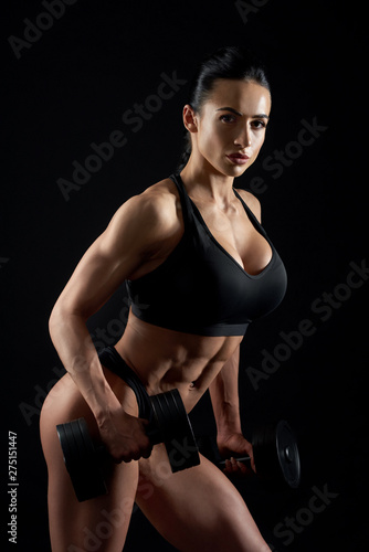 Sexy sportive woman with in black top with dumbbells.
