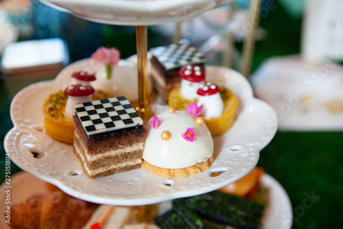 Magical and colorful set of afternoon tea in Alice in Wonderland theme. Tasty and delicious dessert, savories, bakery and pastry. Good for high tea party or Birthday celebration. Natural light.
