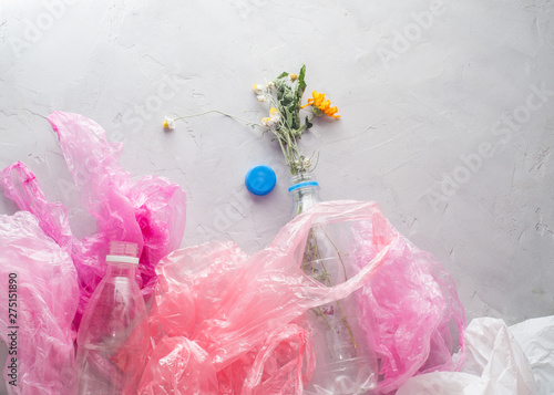 dead flowers in a plastic bottle among the packages photo