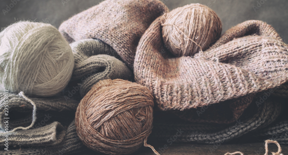 Knitted from a gray yarn sweater and thread for knitting closeup. Knitting as a hobby. Accessories for knitting. Knitted from a gray yarn sweater and thread for knitting closeup. Knitting as a hobby. Accessories for knitting.