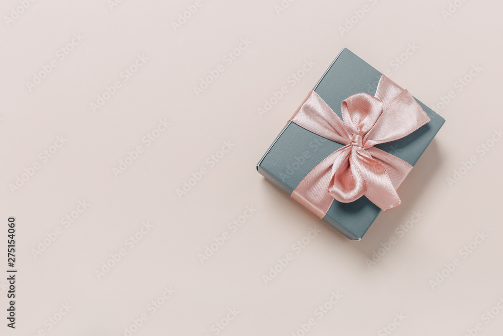 beautiful gift boxes wrapped in paper with gold and pink ribbon on a beige surface. Top view beautiful gift boxes wrapped in paper with gold and pink ribbon on a beige surface. Top view