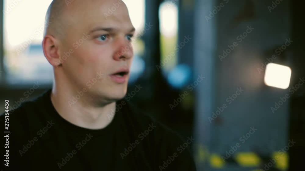 concentrated guy in black dressing lifts black kettlebell and changes hands in sports club closeup slow motion concentrated guy in black dressing lifts black kettlebell and changes hands in sports club closeup slow motion