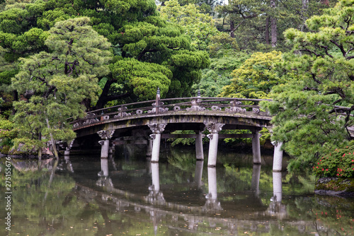 Beautiful scenery at the Kyoto Imperial Palace  with a pond and bridges. On a rainy day  droplets are visible in the air.