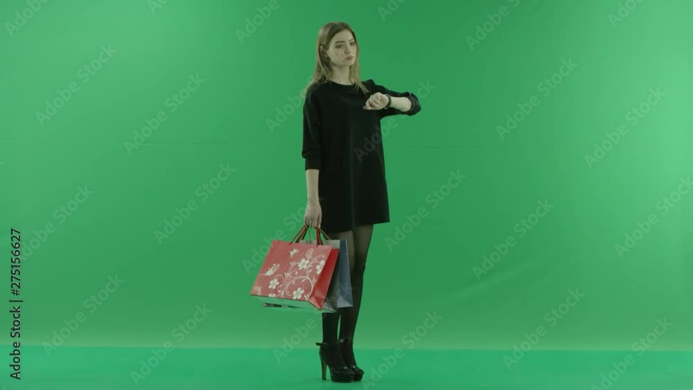 Young woman with shopping bags and watch, chroma key green background Young woman with shopping bags and watch, chroma key green background