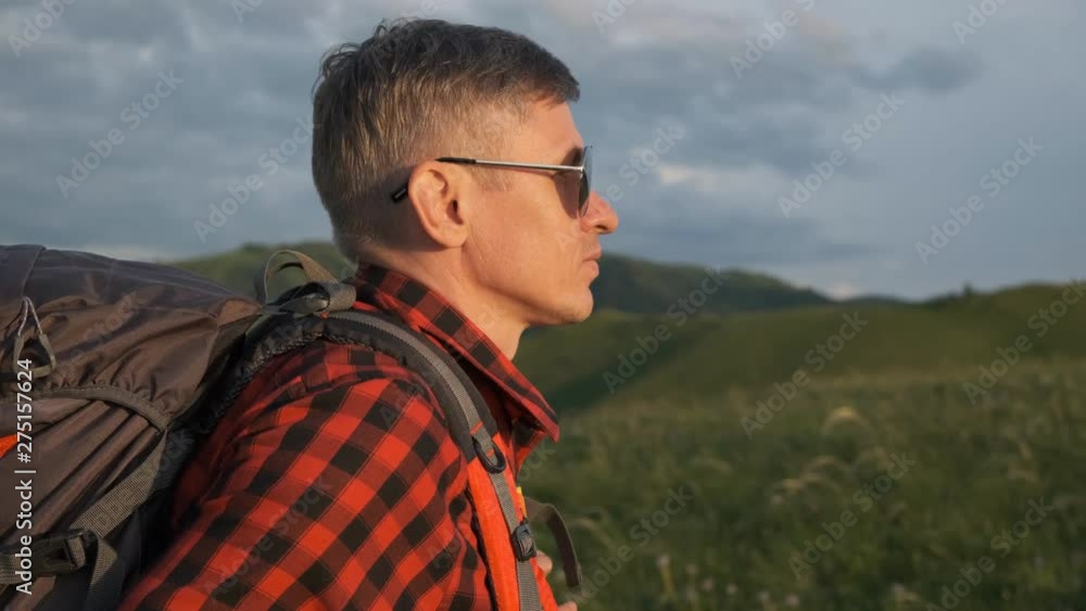 Happy hiker traveler man with backpack climbing up, standing on top of mountain. Hikers raising hands at sunset, enjoying, celebrating success in mountains. hiking successful travel tourism tourist Happy hiker traveler man with backpack climbing up, standing on top of mountain. Hikers raising hands at sunset, enjoying, celebrating success in mountains. hiking successful travel tourism tourist
