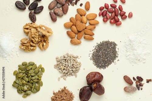 Various superfoods top view. Superfood as coconut powder, spirulina, raw cocoa bean, kerob, walnut, peanut, sunflower and pumpkin seeds.