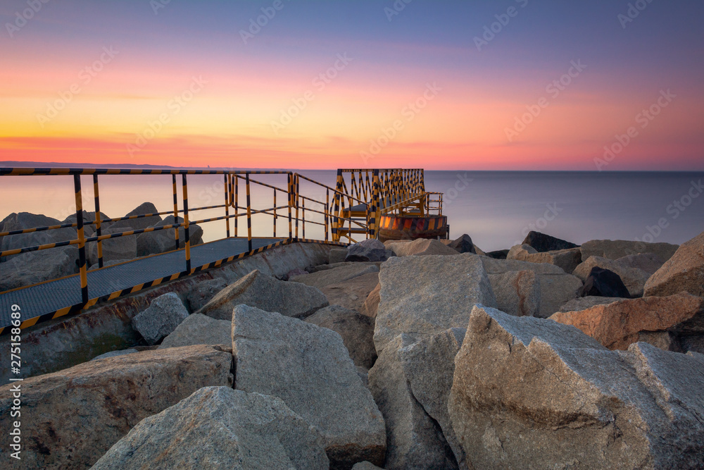 A rocky breakwater overlooking the gulf of Gdansk near the beach at Westerplatte at sunset. Gdansk, Poland