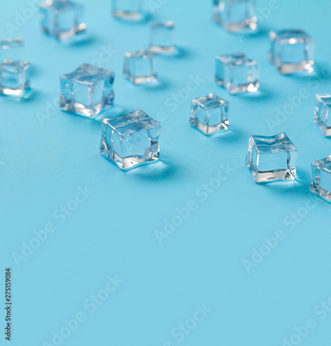 Ice cubes scattered on a light blue background.