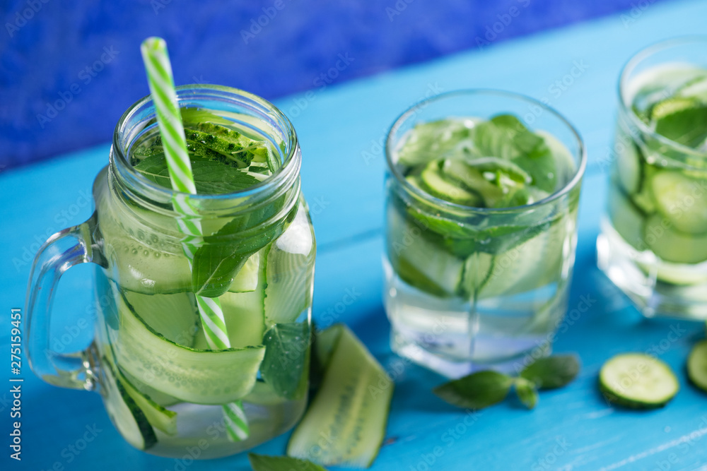 Cucumber infused water with mint on wooden blue background Cucumber infused water with mint on wooden blue background