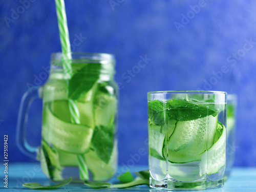 Cucumber infused water with mint on wooden blue background