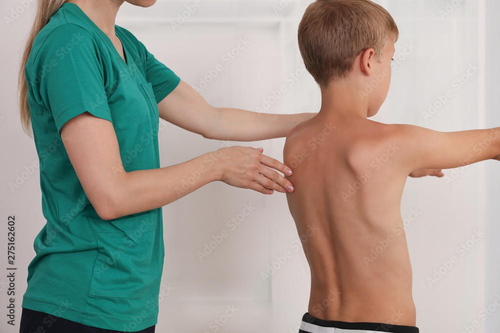 Obraz premium Child having chiropractic back adjustment. Osteopathy, Physiotherapy, Kinesiology. Bad posture correction